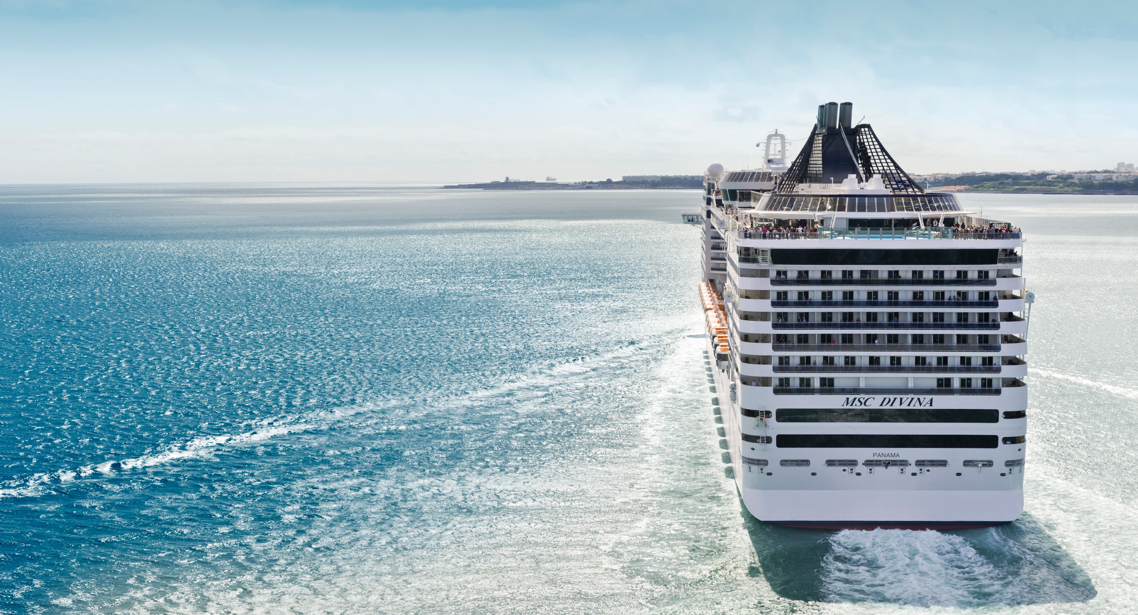 MSC Divina stern aerial underway under a clear sky with DIVINA on the hull